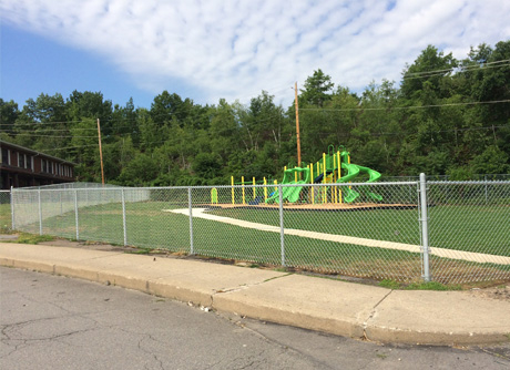 Chain link fence enclosing a school or park playground area — community fencing by Durabilt Fence Company