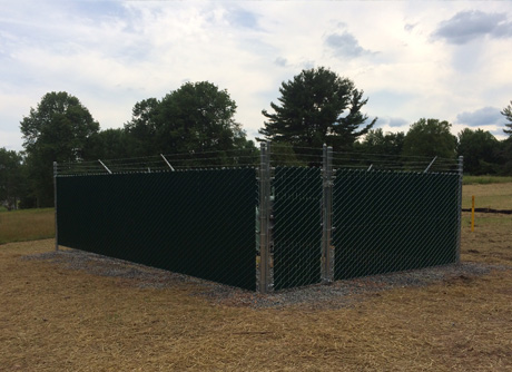 Green privacy slat chain link dumpster and trash enclosure — commercial fence installation