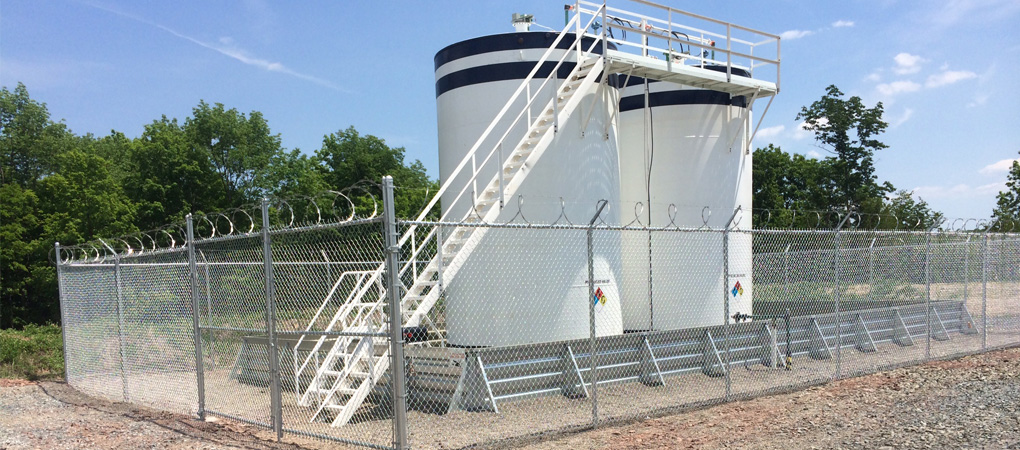 High-security razor wire fencing installed around industrial storage tanks for maximum perimeter protection